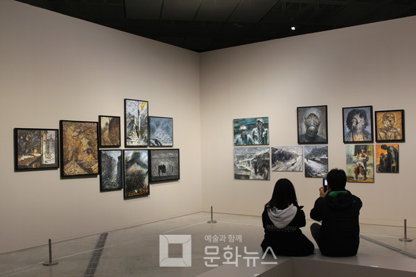 작품을 보며 사진을 찍고 있는 관람객