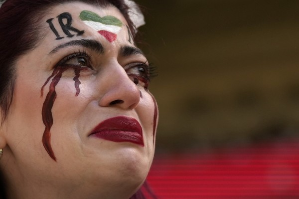 한 이란 여성이 얼굴에 이란 국기와 피눈물을 그려 넣고 25일(현지시간) 카타르에서 열린 월드컵 조별리그 B조 2차전 웨일스와의 경기를 관람하고 있다. AP연합뉴스