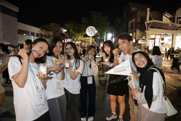 5월 20일 ‘2023 아우르기’ 단원들이 강릉중앙시장에서 한국 간식을 맛보며 전통시장을 탐방하고 있다.