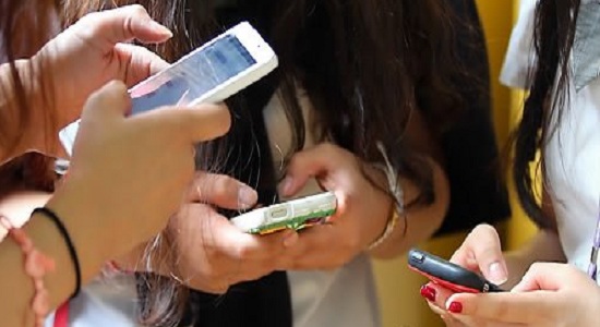 사진 = 여학생들이 스마트폰을 들고 모여있다. 스마트폰의 보급률과 이용 시간 증가도 TV 이용 감소의 원인 중 하나다 / 연합뉴스