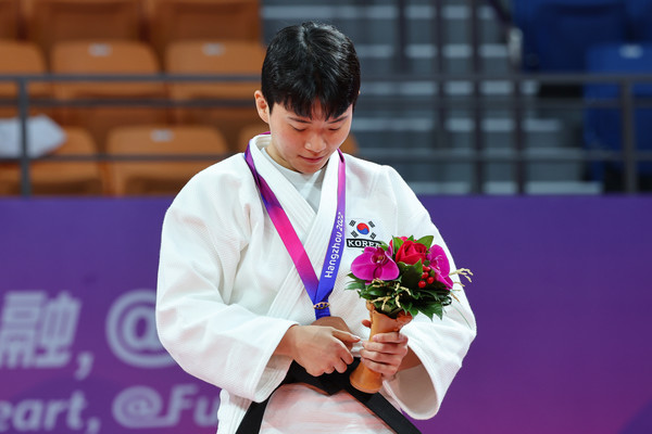 25일 중국 항저우 샤오산 린푸 체육관에서 열린 항저우 아시안게임 유도 여자 63kg급에서 동메달을 획득한 김지정이 시상대에 올라 메달을 바라보고 있다. / 사진= 연합뉴스