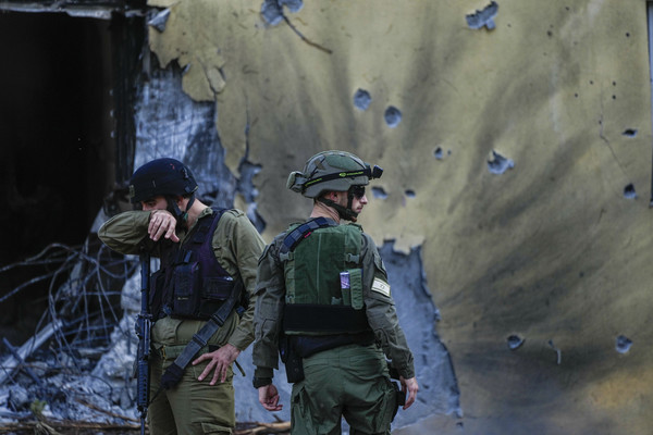 사진 = 이스라엘 키부츠 베에리에서 이스라엘 군인들이 하마스 무장세력에 의해 파괴된 집들을 지나가고 있다 / 연합뉴스 제공