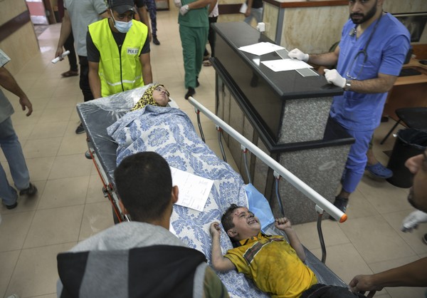 사진 = 17일(현지시간) 가자지구에서 이스라엘 공습으로 다친 주민들이 병원으로 이송되고 있다. 지난 7일 팔레스타인 무장 정파 하마스가 이스라엘을 공격한 뒤 교전이 벌어져 양측에서 4천 명 이상이 사망했다 / AP=연합뉴스 제공