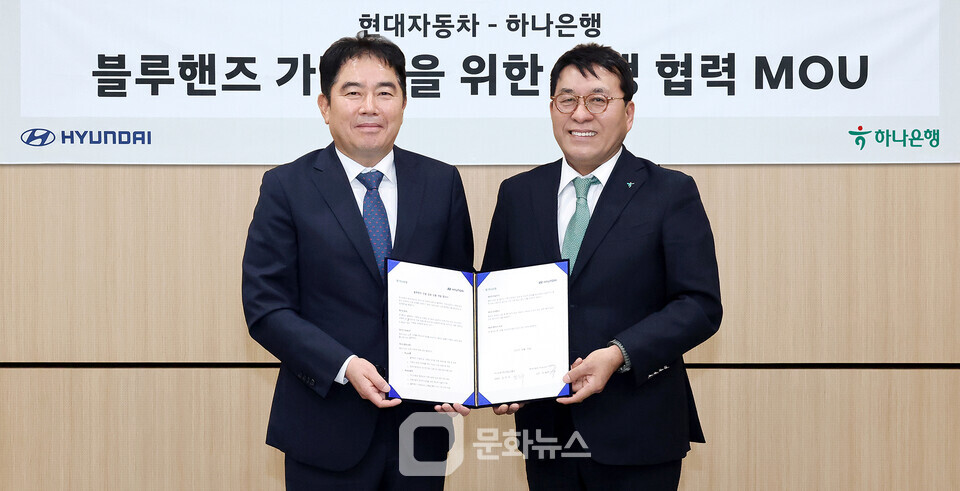 하나은행은 지난 4월 30일 현대자동차와 블루핸즈 가맹점 금융지원을 위한 업무협약을 체결했다. 이날 협약식에 참석한 김진우 하나은행 중앙영업그룹 부행장(사진 오른쪽)이 이용섭 현대자동차 국내사업본부 국내서비스사업부 상무(사진 왼쪽)와 함께 협약서를 들고 기념 촬영을 하고 있다. / 사진제공=하나은행
