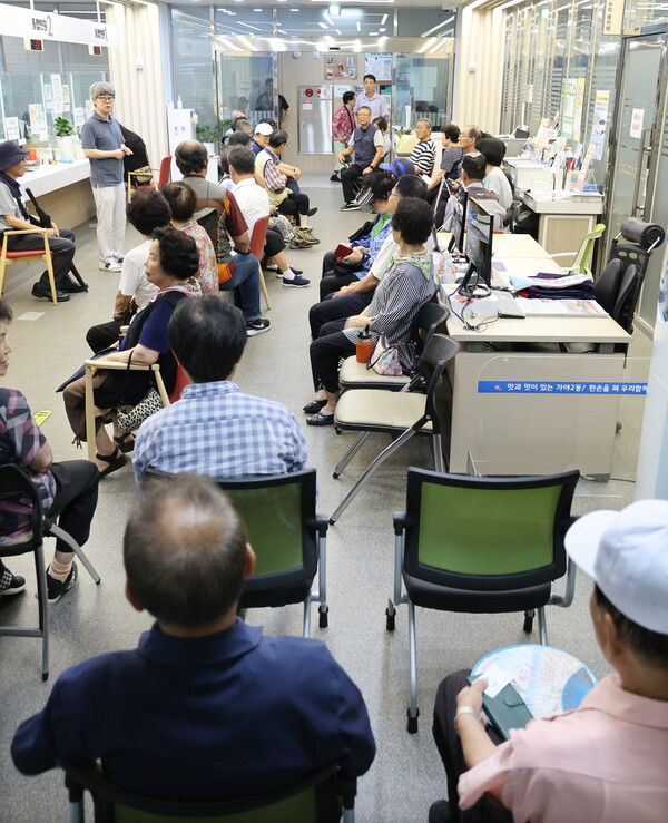 민생회복 소비쿠폰 1차 신청 첫날인 지난 21일 부산 부산진구 가야2동 행정복지센터에서 어르신들이 번호표를 받고 대기하며 순서를 기다리고 있다.