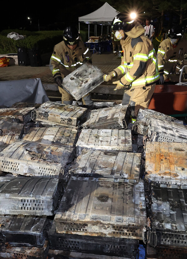 지난 27일 밤 대전 유성구 국가정보자원관리원 화재 현장에서 소방대원들이 불에 탄 리튬이온 배터리를 소화수조로 옮기고 있다. 대전 연합뉴스