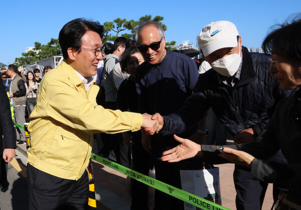 김민석 국무총리가 15일 부산 광안리해수욕장 일대를 돌아보며 부산불꽃축제 안전관리상황을 점검하던 중 시민들과 인사를 나누고 있다./연합뉴스